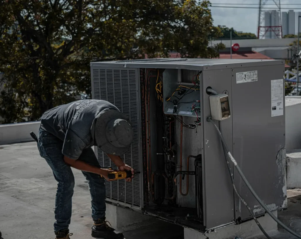 Técnico trabalhando em equipamento de climatização na cobertura