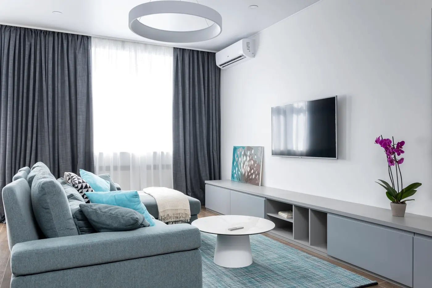 Sala com ar-condicionado split acima do painel da televisão