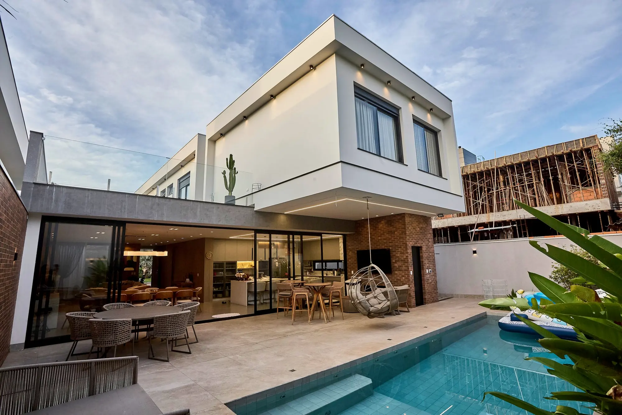 Casa de alto padrão com piscina e fachada em concreto e vidro