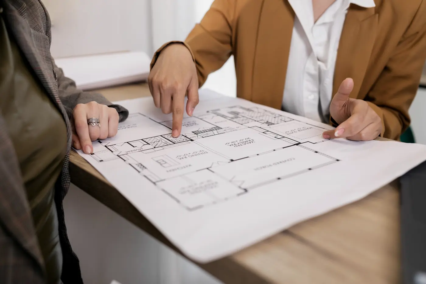 Planta de arquitetura sendo revisada sobre a mesa