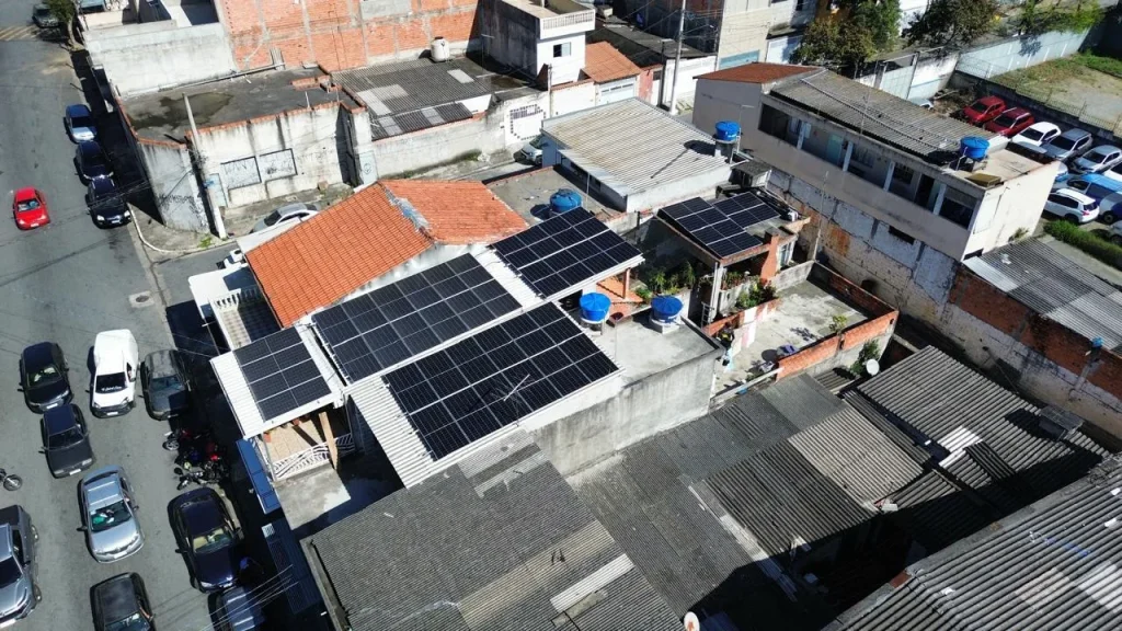 Sistemas fotovoltaicos em telhados de casas vizinhas, vistos por drone — obra da ORYGEN